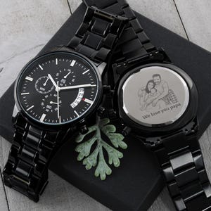 Custom photo laser engraved wooden wristwatch with a personalized family picture on the back dial, luxury leather strap close-up shot.
