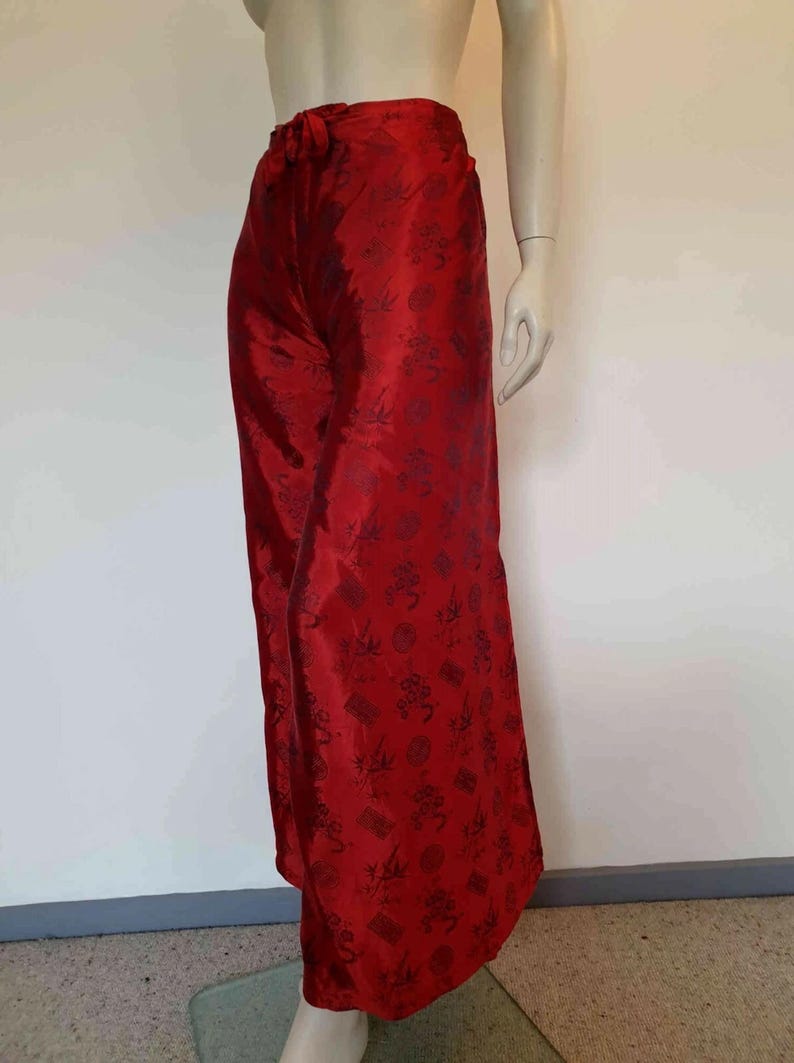 Beautiful red figured silk pants custom made in Hoi An, Vietnam. In the style of fishermen's pants, they tie at the waist, are passed between the legs and tie at the waist again. Wide legged, the sides are over lapped and not fastened.  Medium.
