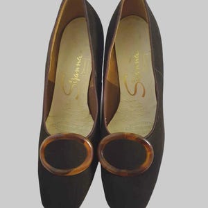 Vintage Vintage Chocolate brown suede pumps have squared off toes and large faux tortoiseshell (plastic) buckle trim. Mid height heels. Leather half lining, insoles and soles. Brand is Siranna by Westbrook - 1960s. Size Au/US 6C