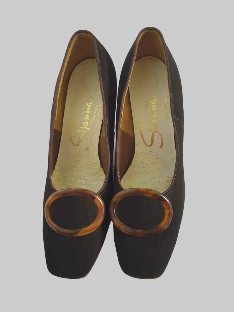 Vintage Vintage Chocolate brown suede pumps have squared off toes and large faux tortoiseshell (plastic) buckle trim. Mid height heels. Leather half lining, insoles and soles. Brand is Siranna by Westbrook - 1960s. Size Au/US 6C