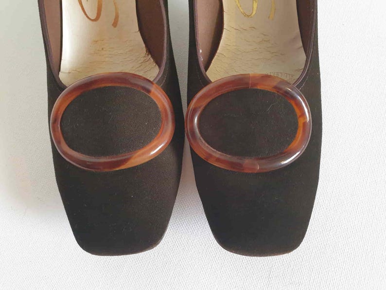 Vintage Vintage Chocolate brown suede pumps have squared off toes and large faux tortoiseshell (plastic) buckle trim. Mid height heels. Leather half lining, insoles and soles. Brand is Siranna by Westbrook - 1960s. Size Au/US 6C