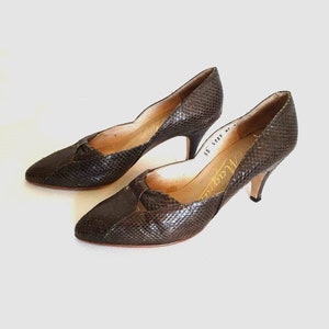 May include: A pair of brown snakeskin heeled pumps with a pointed toe and a small cut-out detail on the vamp. The shoes are labelled "Magnanni" and "35 6089 42".