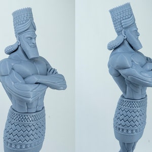 May include: A 3D printed gray figurine of a muscular figure wearing a crown and a skirt. The figure has its arms crossed and is standing with its weight on one leg.