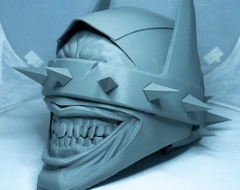 May include: A gray 3D printed Batman mask with a Joker-like smile and a spiked visor.