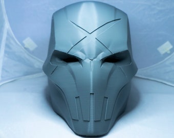 May include: A gray 3D printed mask with a skull-like design. The mask has a prominent X on the forehead and a series of vertical lines on the lower face.