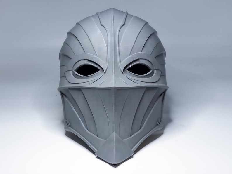 May include: A gray, detailed, helmet-like mask with eye holes and a pointed chin.