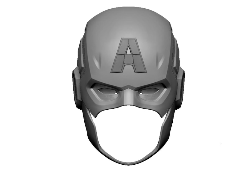 Op de afbeelding: Een grijze, 3D-geprinte Captain America-helm. De helm heeft de letter "A" op het voorhoofd en openingen voor de ogen. Het ontwerp is een gestileerde weergave van de iconische hoofddeksel van de superheld.