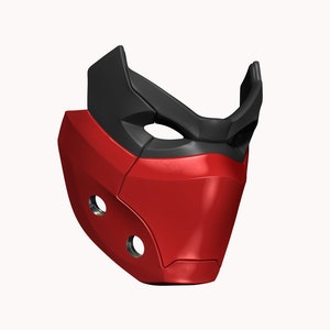 Peut inclure: Un masque en plastique rouge et noir avec un design g&eacute;om&eacute;trique. Le masque a deux petits trous sur le c&ocirc;t&eacute; et une ouverture plus grande pour les yeux.