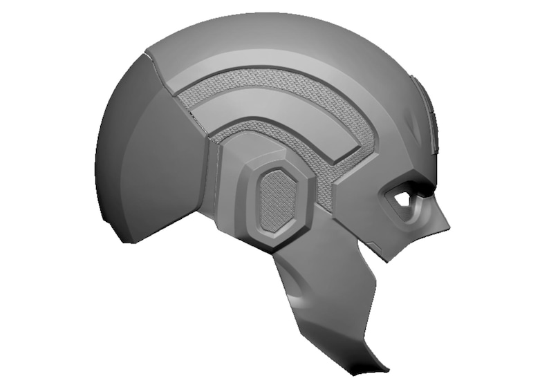 Op de afbeelding: Een grijze, futuristische helm met een getextureerd paneel op de kruin en geometrische details. De helm heeft een viziergedeelte en een kinbeschermer, wat wijst op een ontwerp voor bescherming of cosplay.