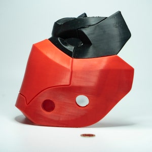 Peut inclure: Un masque rouge et noir imprim&eacute; en 3D avec un design g&eacute;om&eacute;trique. Le masque a deux trous sur le c&ocirc;t&eacute; et un petit trou sur le dessus.