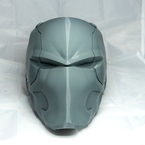 May include: A gray, 3D printed helmet with a futuristic design. The helmet has a visor and a detailed faceplate.