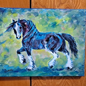 May include: A painting of a black and white horse with blue and green accents. The horse is standing on a green field with a blue sky in the background. The painting is signed "ESHEE" in the bottom left corner.