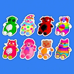 Könnte beinhalten: Acht bunte Plüschtieraufkleber auf blauem Hintergrund. Die Aufkleber zeigen verschiedene Designs, darunter ein Alien, ein Clown, ein Teufel, ein Bär, eine Katze, ein rosa Bär, ein Teddybär und eine Piñata. Jeder Aufkleber hat einen weißen Rand.