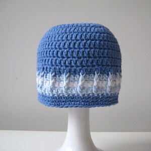 Puede incluir: Un gorro de punto azul con una franja blanca y azul claro alrededor del borde.