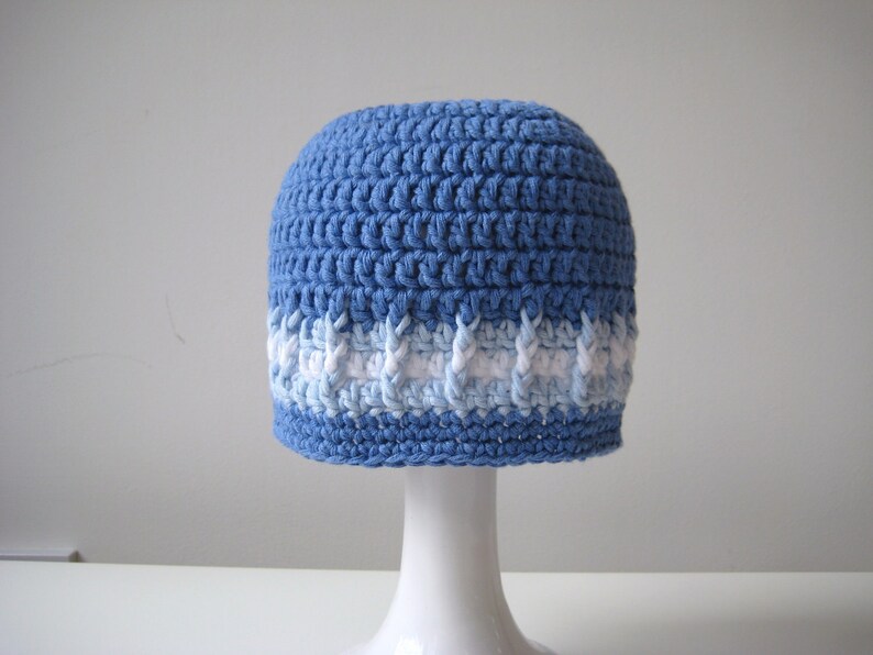 Puede incluir: Un gorro de punto azul con una franja blanca y azul claro alrededor del borde.