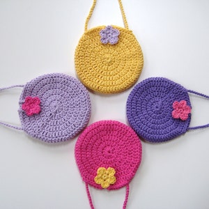 May include: Four crocheted purses with flower embellishments. The purses are in shades of yellow, purple, and pink.