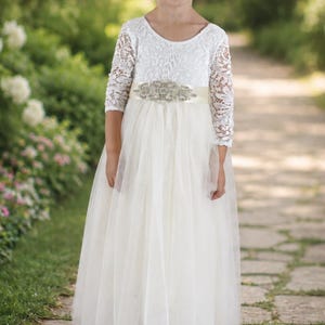 Toddler flower girl dress in ivory with lace long sleeves and full-length tulle skirt.