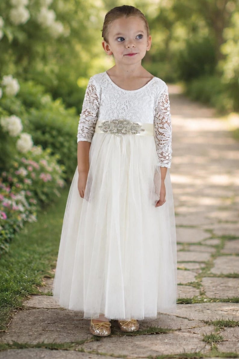 Toddler flower girl dress in ivory with lace long sleeves and full-length tulle skirt.
