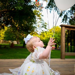 1st birthday white floral dress. A white dress with floral embroidery in short sleeve in tulle. built in romper.
