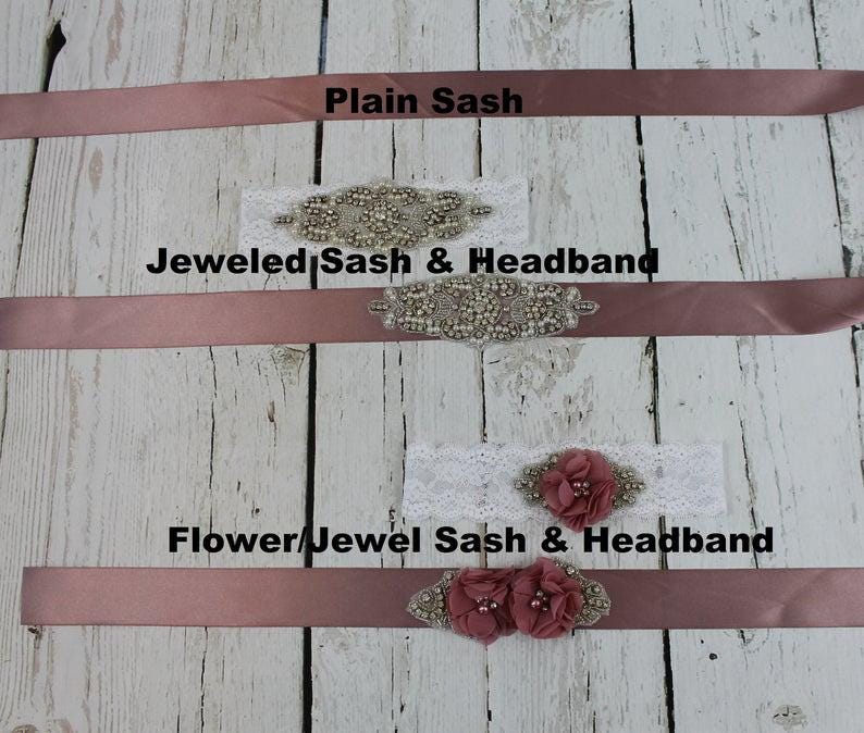 May include: Three different styles of sashes and headbands. The top sash is plain dusty rose. The middle sash has a jeweled embellishment and the text "Jeweled Sash & Headband". The bottom sash has a flower and jeweled embellishment and the text "Flower/Jewel Sash & Headband".