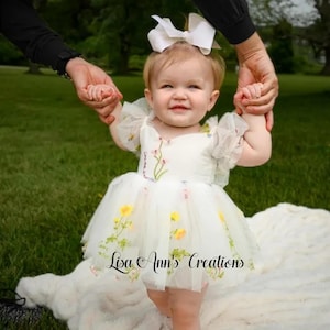 Birthday or flower girl dress. A white tulle dress with embroidered flowers. The dress has a sweetheart neckline and short sleeves. Design Lisa Ann's Creations.