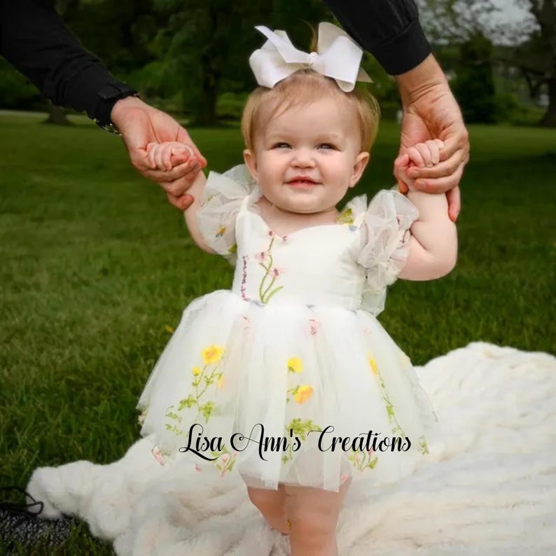 Birthday or flower girl dress. A white tulle dress with embroidered flowers. The dress has a sweetheart neckline and short sleeves. Design Lisa Ann's Creations.