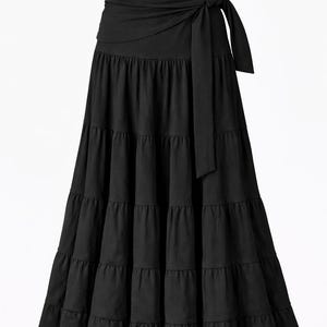 May include: Black tiered maxi skirt with a wrap tie. The skirt features a high waist and a flowing, tiered design. The brand name "kalbella" is visible on the waistband. The word "Black" is in the upper right corner.