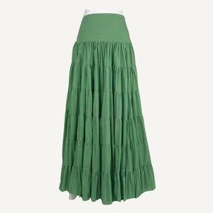 May include: A mint green tiered maxi skirt. The skirt has a wide waistband and multiple layers of gathered fabric, creating a flowing silhouette. The skirt is made of a lightweight material and is suitable for casual wear.