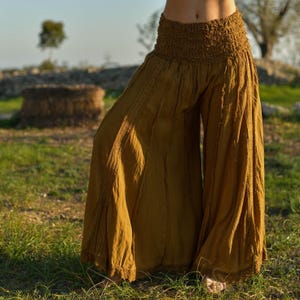 May include: Mustard yellow wide-leg pants with a gathered elastic waistband.