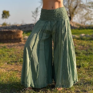 May include: Sage green wide-leg pants with a gathered elastic waistband and a flowing, layered design.