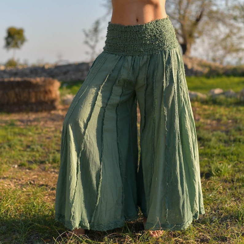May include: Sage green wide-leg pants with a gathered elastic waistband and a flowing, layered design.