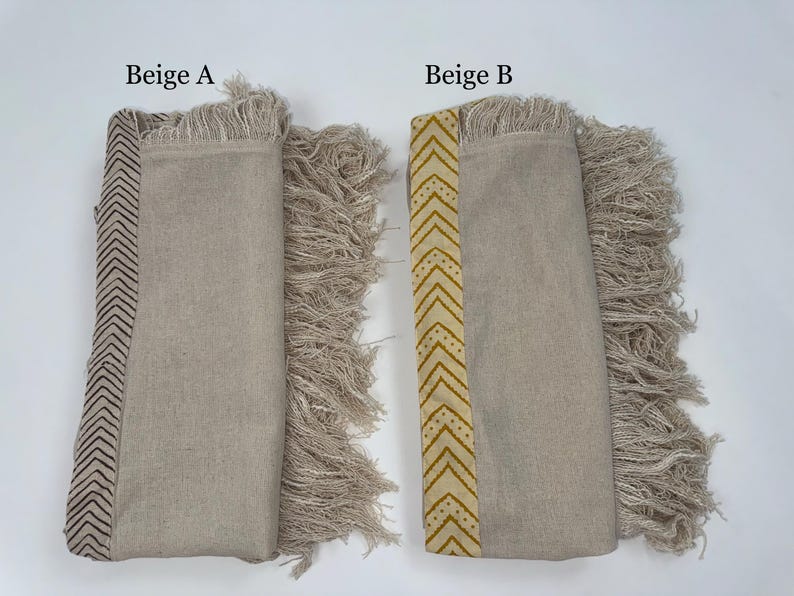 May include: Two beige textile items with fringed edges. One has a dark brown chevron pattern, the other has a yellow chevron pattern. The text "Beige A" and "Beige B" are visible.