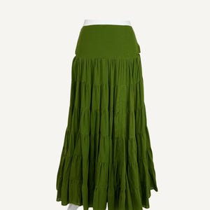May include: A light green tiered maxi skirt. The skirt has a wide waistband and multiple horizontal rows of fabric that create a flowing, layered effect. The text "Light Green" is in the upper right corner.