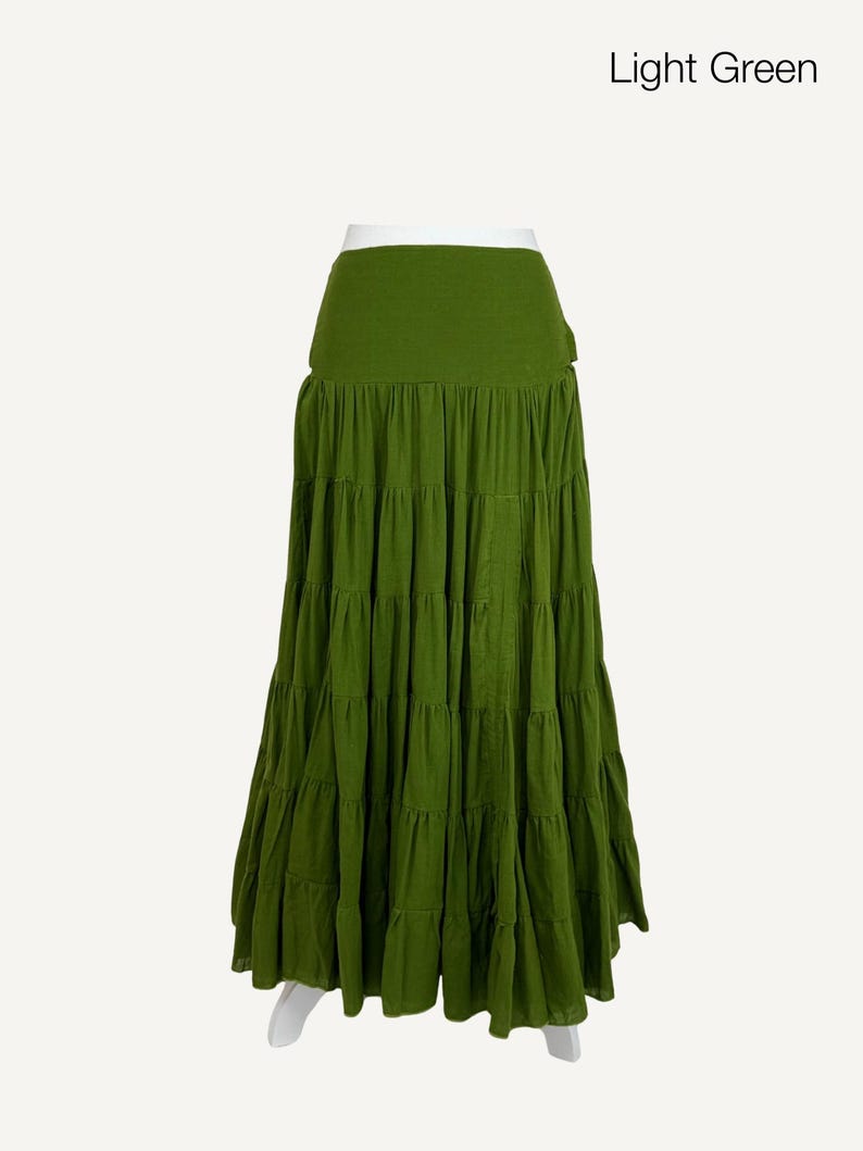 May include: A light green tiered maxi skirt. The skirt has a wide waistband and multiple horizontal rows of fabric that create a flowing, layered effect. The text "Light Green" is in the upper right corner.