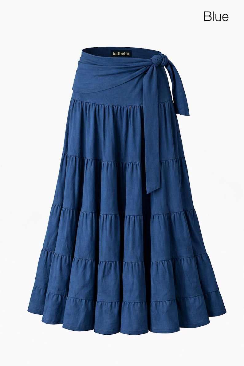 May include: A tiered, floor-length blue skirt with a wrap-around tie at the waist. The skirt has a flowing silhouette and is made of a soft fabric. The word "Blue" is in the upper right corner. The brand name "kalbella" is visible.