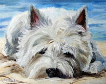 May include: A white West Highland White Terrier dog with fluffy white fur is lying on its side on a sandy beach. The dog's head is resting on the sand, and its eyes are closed. The dog's ears are floppy and its nose is black.