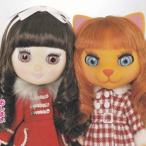 May include: Two dolls wearing red and white checkered dresses. The doll on the left has brown hair and pink eyes. The doll on the right has orange hair and blue eyes. The doll on the left is wearing a white fur collar and the doll on the right is wearing a white collar. The text "おしまい" is written on the left side of the image.