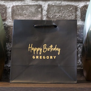 Pu&ograve; includere: Busta regalo nera con scritta dorata "Happy Birthday GREGORY".