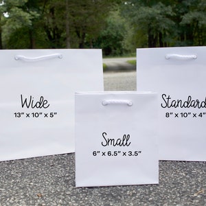 Pode incluir: Tr&ecirc;s sacos de presente brancos de diferentes tamanhos. O saco maior &eacute; etiquetado "Wide 13" x 10" x 5"". O saco do meio &eacute; etiquetado "Small 6" x 6,5" x 3,5"". O saco menor &eacute; etiquetado "Standard 8" x 10" x 4"".