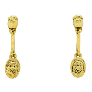 May include: A pair of gold-tone dangle earrings featuring a Winnie the Pooh character charm.