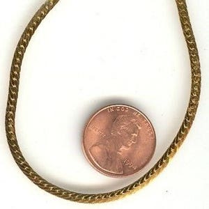 May include: A gold chain bracelet with a lobster clasp closure. The chain is a woven design and is about the size of a US penny.