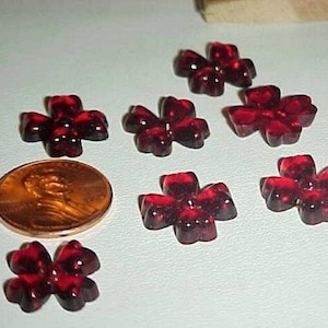 May include: Eight red glass flower-shaped buttons with a black and red marbled pattern.