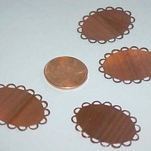 May include: Four copper oval-shaped metal blanks with a scalloped edge. The blanks are approximately the size of a US penny.