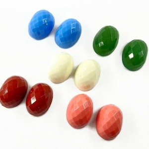 May include: Eight oval-shaped buttons in various colours, including red, blue, green, white, and pink. The buttons have a faceted, textured surface.