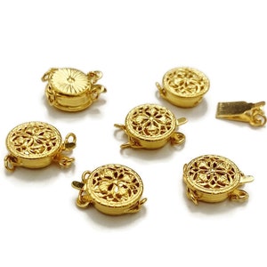 Könnte beinhalten: Sechs goldfarbene Metallverschlüsse für Halsketten oder Armbänder. Jeder Verschluss hat ein dekoratives, filigranes Blumenmuster.