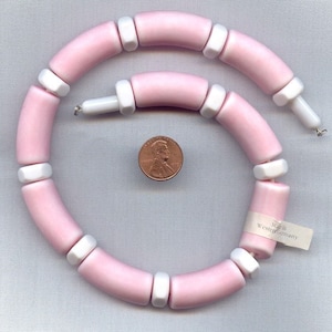 May include: A pink and white ceramic bead necklace with a silver clasp. The necklace is made in Western Germany.