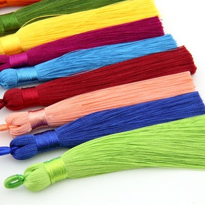 May include: A set of ten colorful tassels, each with a different color, including yellow, red, blue, green, and pink. The tassels are made of soft, silky material and are perfect for adding a touch of color and texture to any project.