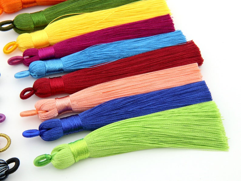 May include: A set of ten colorful tassels, each with a different color, including yellow, red, blue, green, and pink. The tassels are made of soft, silky material and are perfect for adding a touch of color and texture to any project.