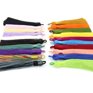 May include: Assortment of 18 colorful silk tassels with a variety of colors including black, white, pink, purple, green, blue, red, orange, and yellow.