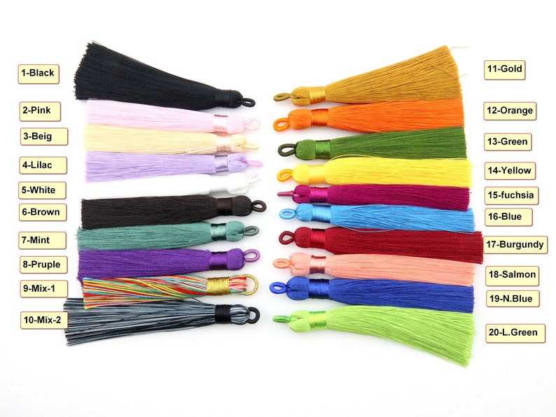 May include: Twenty different colors of tassel trim, each with a different color name label. The tassels are all the same size and shape, and they are arranged in two rows of ten.